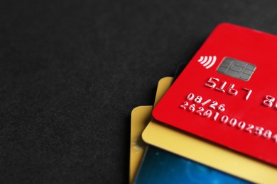 Photo of Different credit cards on black background, closeup. Space for text