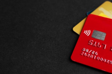 Different credit cards on black background, closeup. Space for text