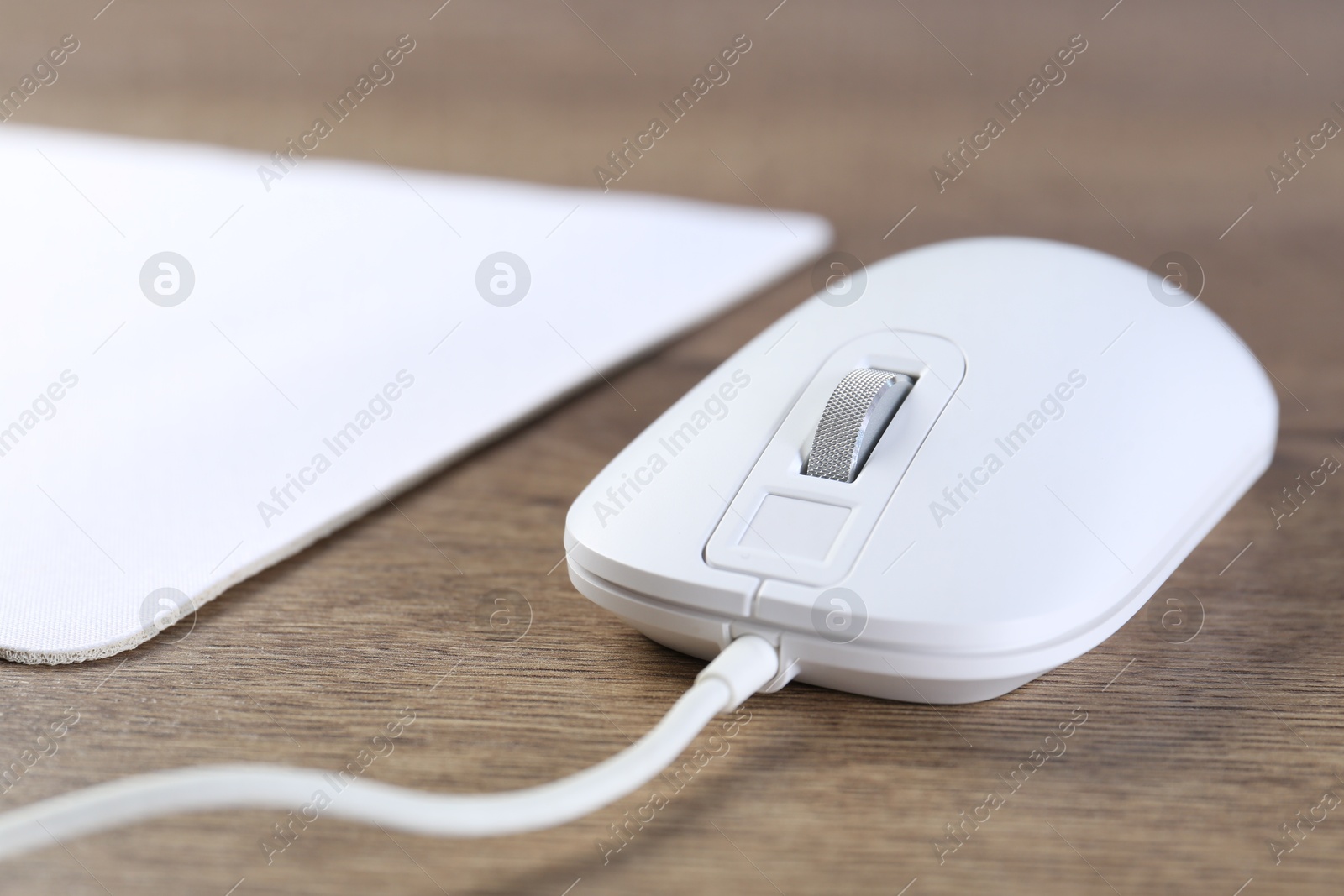 Photo of Computer mouse on wooden table, closeup view