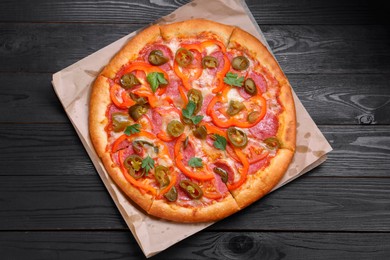 Photo of Delicious pizza Diablo on black wooden table, top view