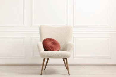 Photo of Soft armchair with pillow in light room