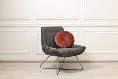 Photo of Soft armchair with pillow in light room