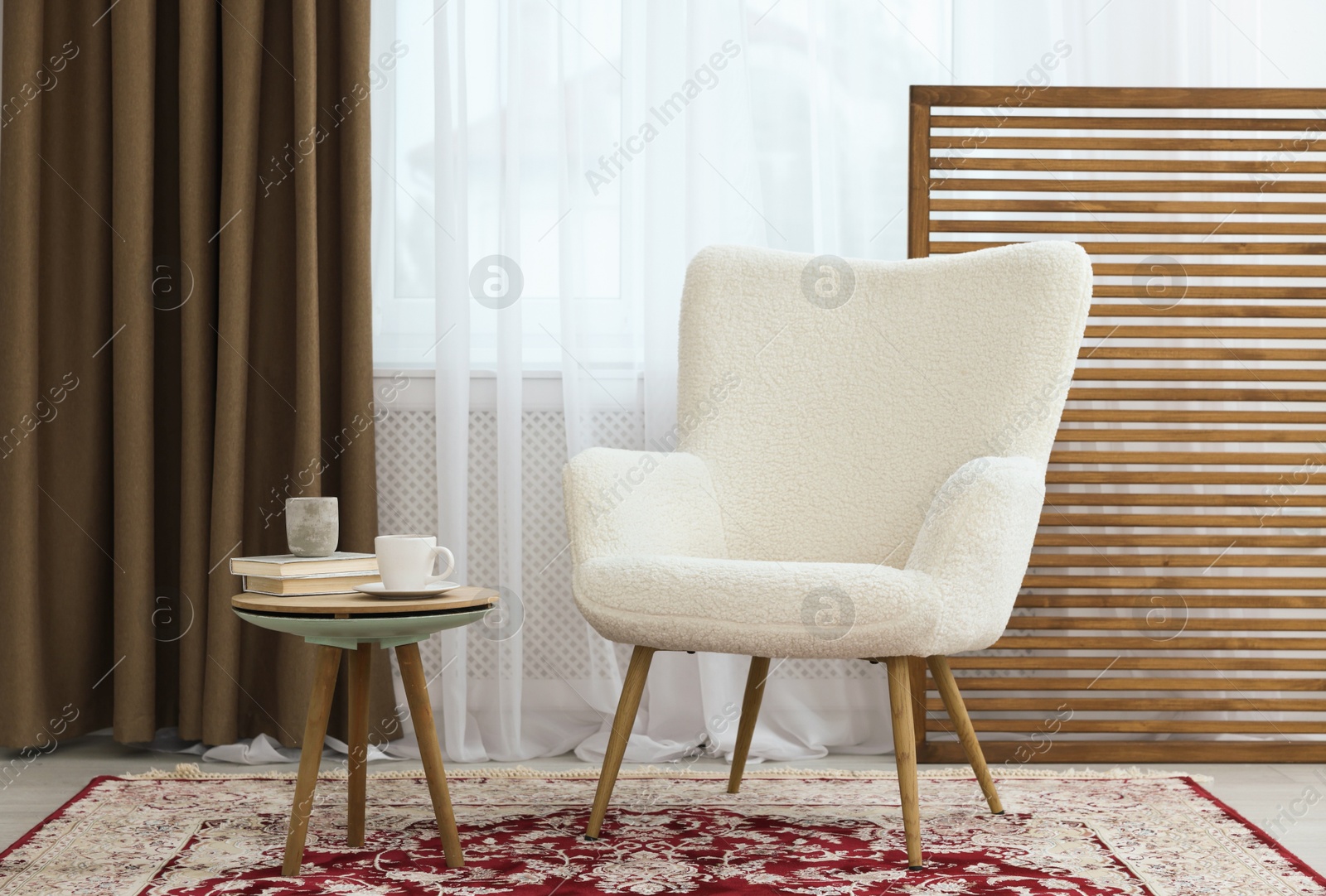 Photo of Soft armchair, coffee table and window with curtains in room. Interior design