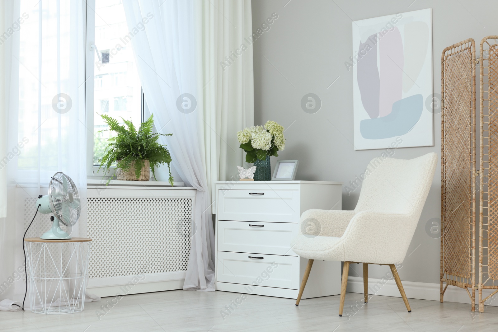 Photo of Soft armchair, chest of drawers, houseplant and window with curtains in room. Interior design