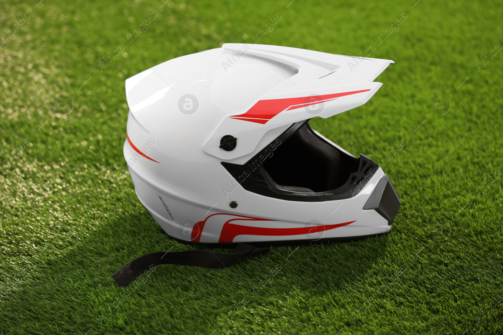 Photo of Modern motorcycle helmet with visor on green grass