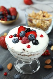 Tasty yogurt with fresh berries on table, closeup