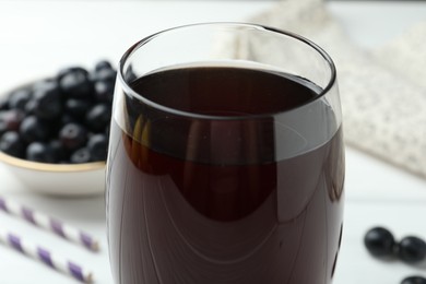 Photo of Tasty fresh acai juice in glass on white table, closeup