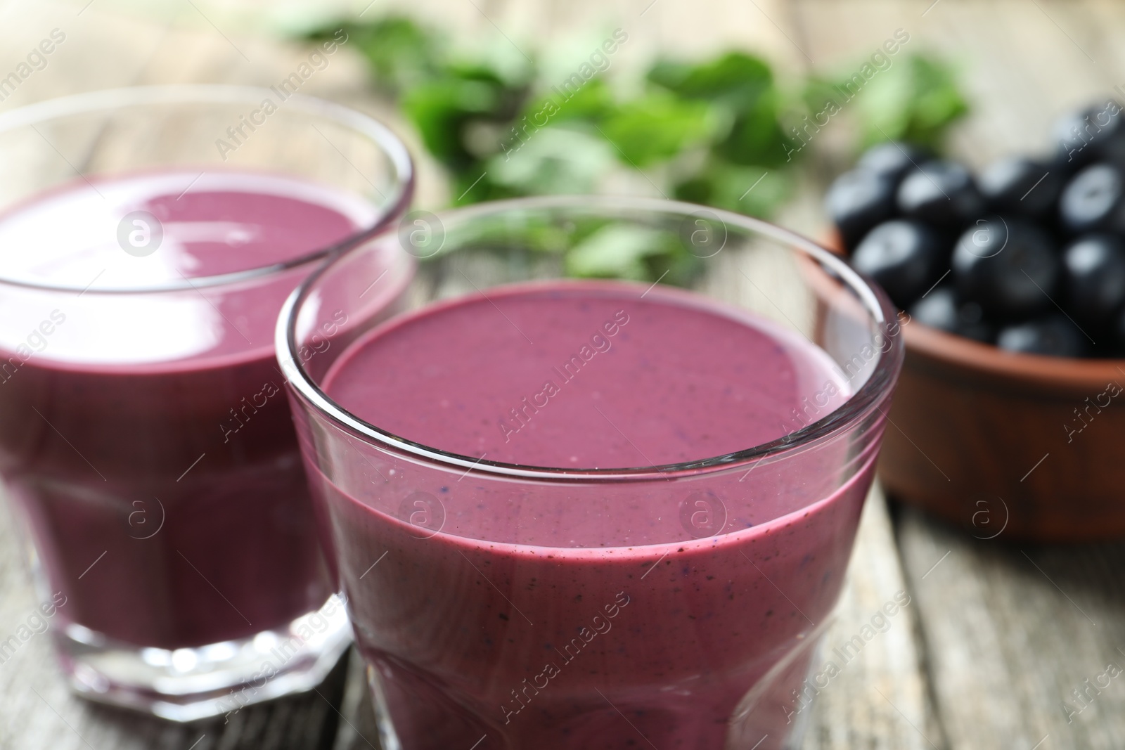 Photo of Tasty fresh acai juice in glasses on table, closeup