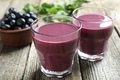 Photo of Tasty fresh acai juice in glasses on table, closeup