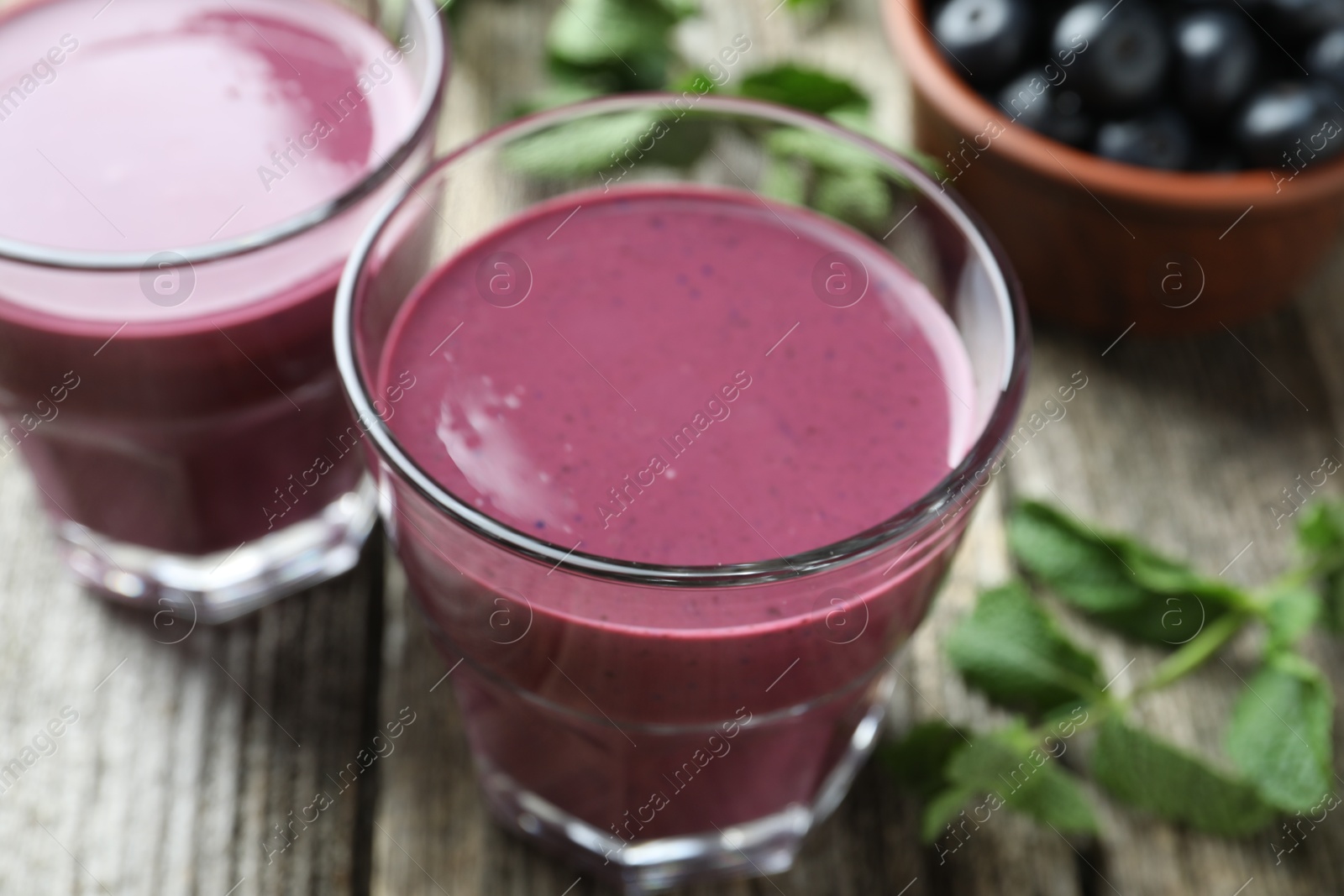 Photo of Tasty fresh acai juice in glasses on table, closeup