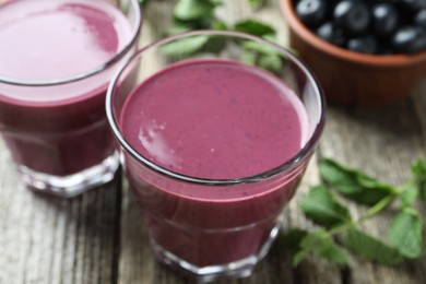 Tasty fresh acai juice in glasses on table, closeup