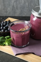 Photo of Tasty fresh acai juice with mint and berries on grey table