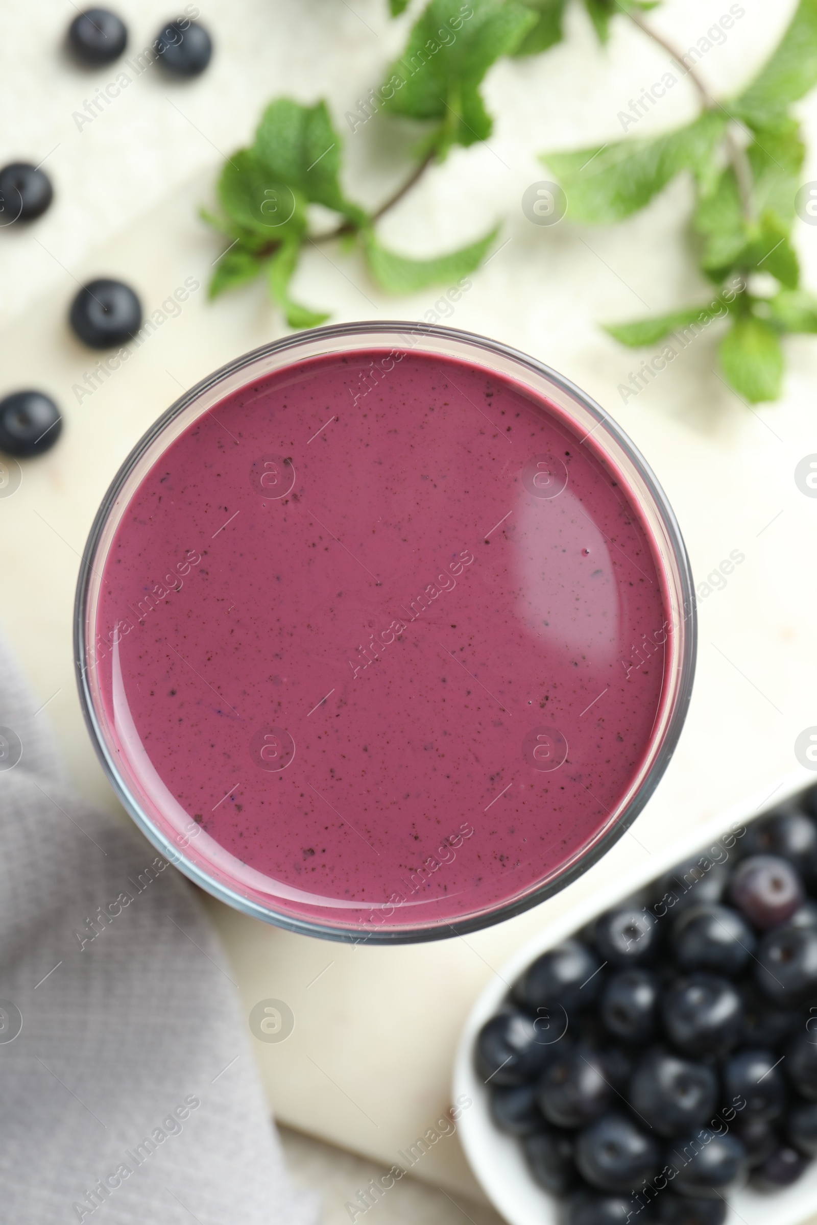 Photo of Tasty fresh acai juice in glass on light table, top view