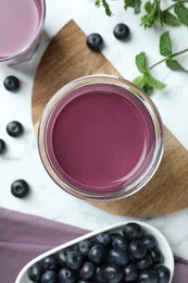 Photo of Tasty fresh acai juice in glasses, mint and berries on white marble table, flat lay