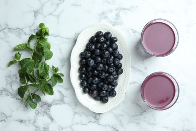 Photo of Tasty fresh acai juice in glasses, mint and berries on white marble table, flat lay