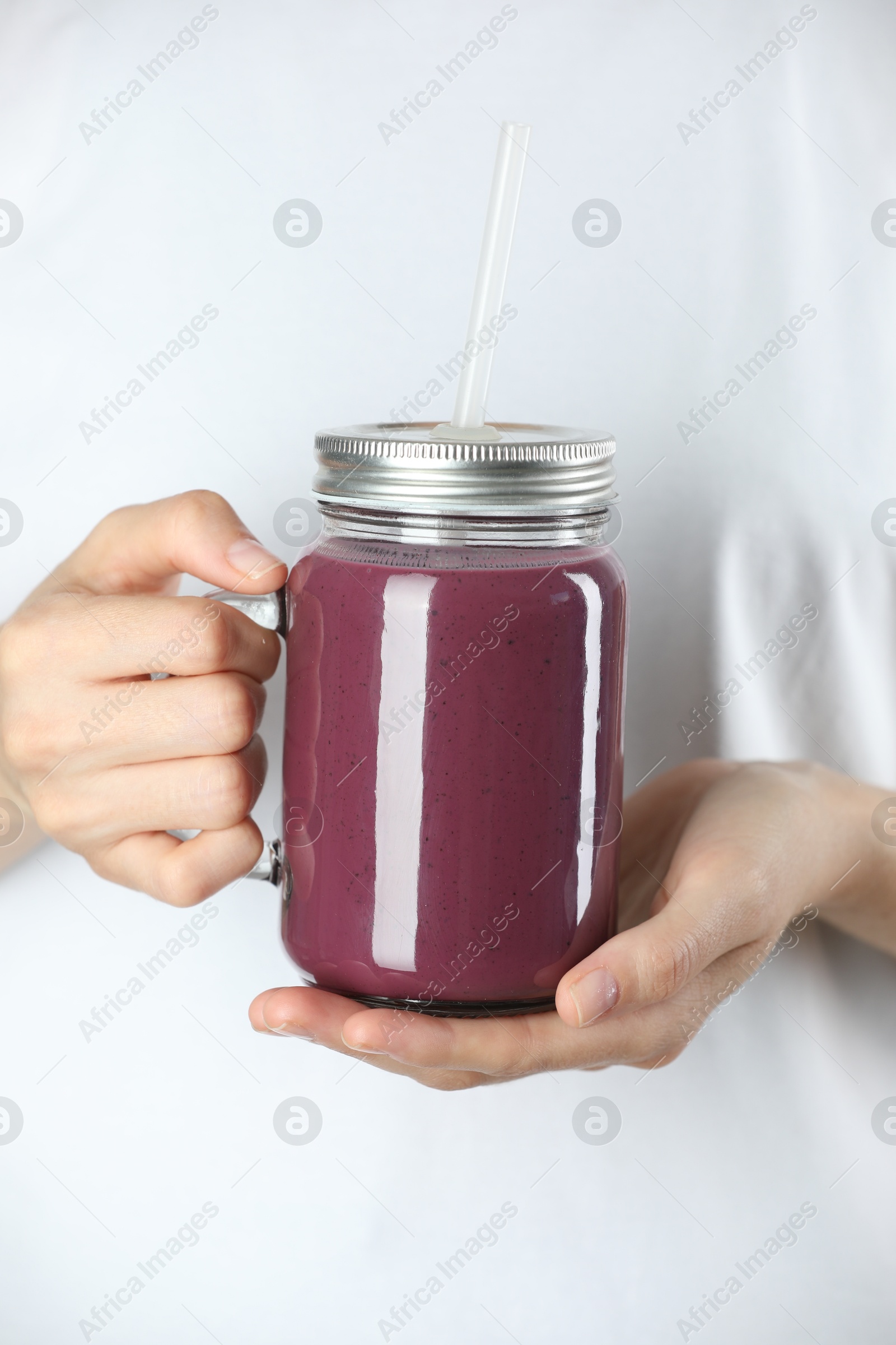 Photo of Woman with mason jar of tasty fresh acai juice, closeup