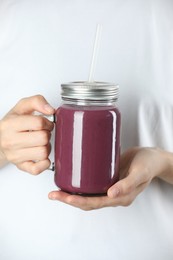 Photo of Woman with mason jar of tasty fresh acai juice, closeup