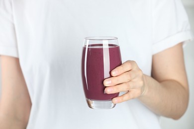 Photo of Woman with glass of tasty fresh acai juice, closeup