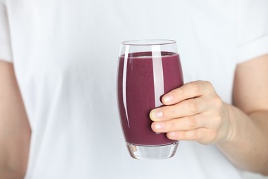 Photo of Woman with glass of tasty fresh acai juice, closeup