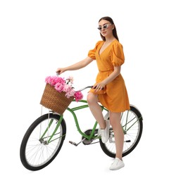 Photo of Woman in sunglasses with bicycle and basket of peony flowers against white background