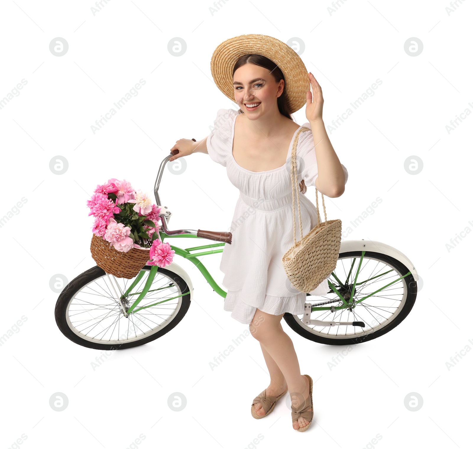 Photo of Beautiful young woman with bicycle and basket of peony flowers isolated on white