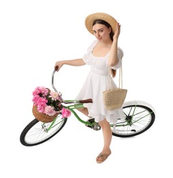 Photo of Beautiful young woman with bicycle and basket of peony flowers isolated on white