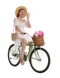 Photo of Happy woman riding bicycle with basket of peony flowers on white background