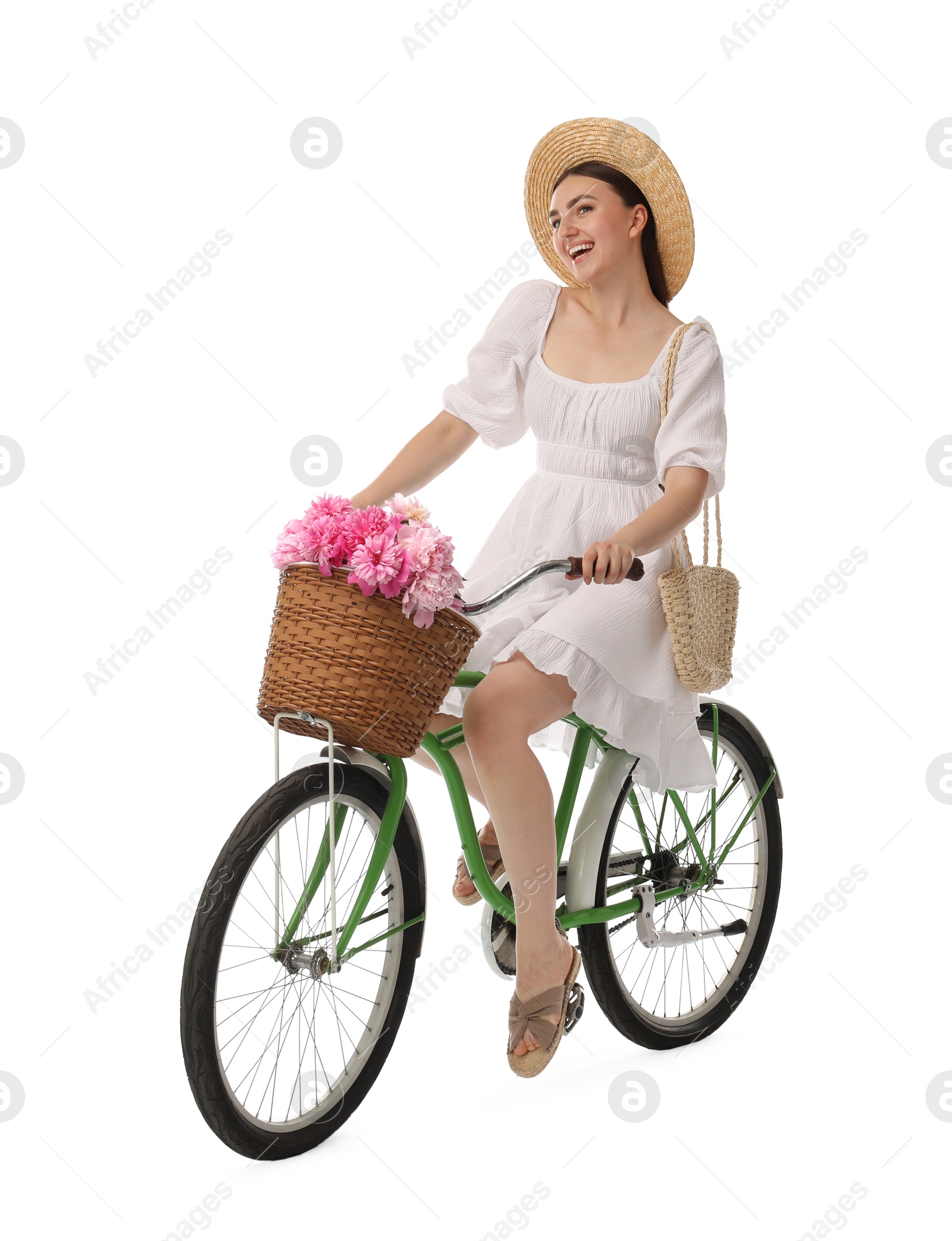 Photo of Smiling woman on bicycle with basket of peony flowers against white background