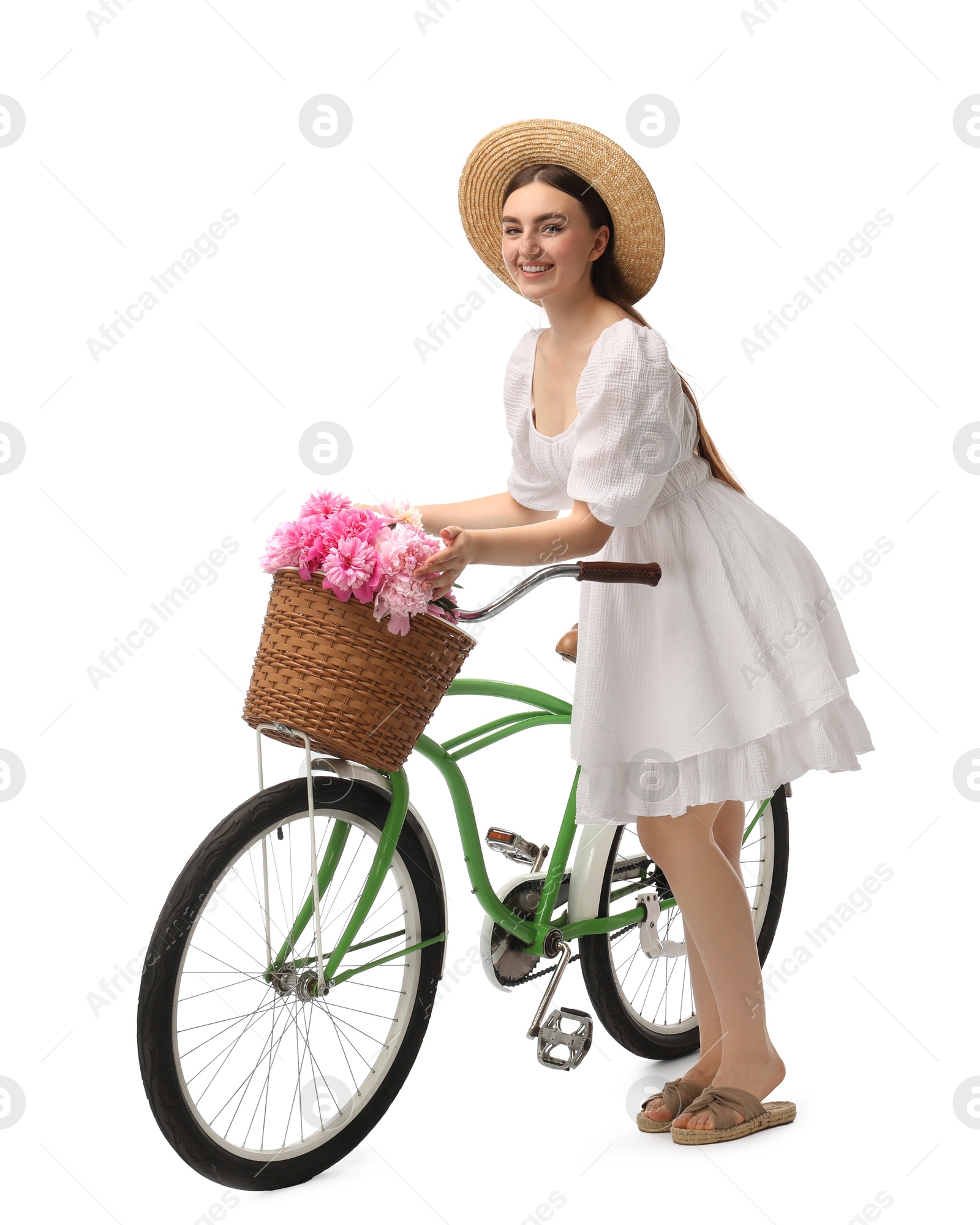 Photo of Smiling woman with bicycle and basket of peony flowers isolated on white