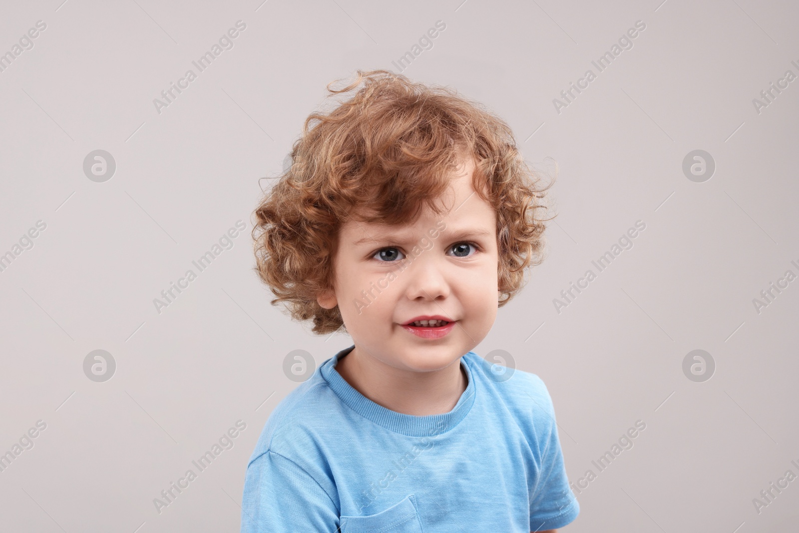 Photo of Portrait of cute little boy on grey background