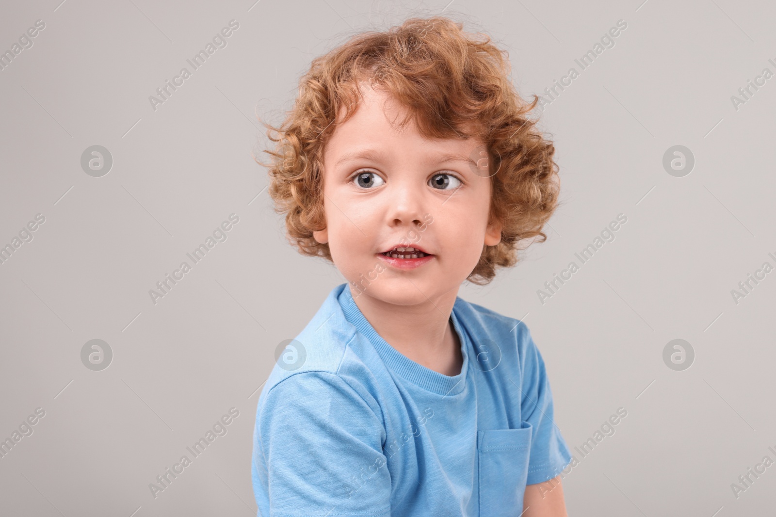 Photo of Portrait of cute little boy on grey background