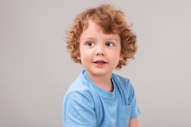 Photo of Portrait of cute little boy on grey background