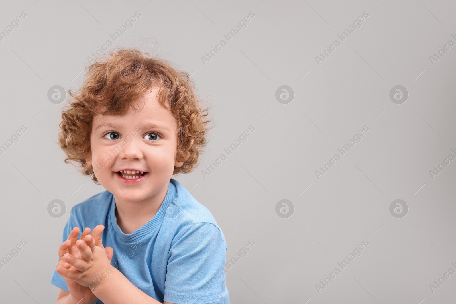 Photo of Portrait of cute little boy on grey background, space for text