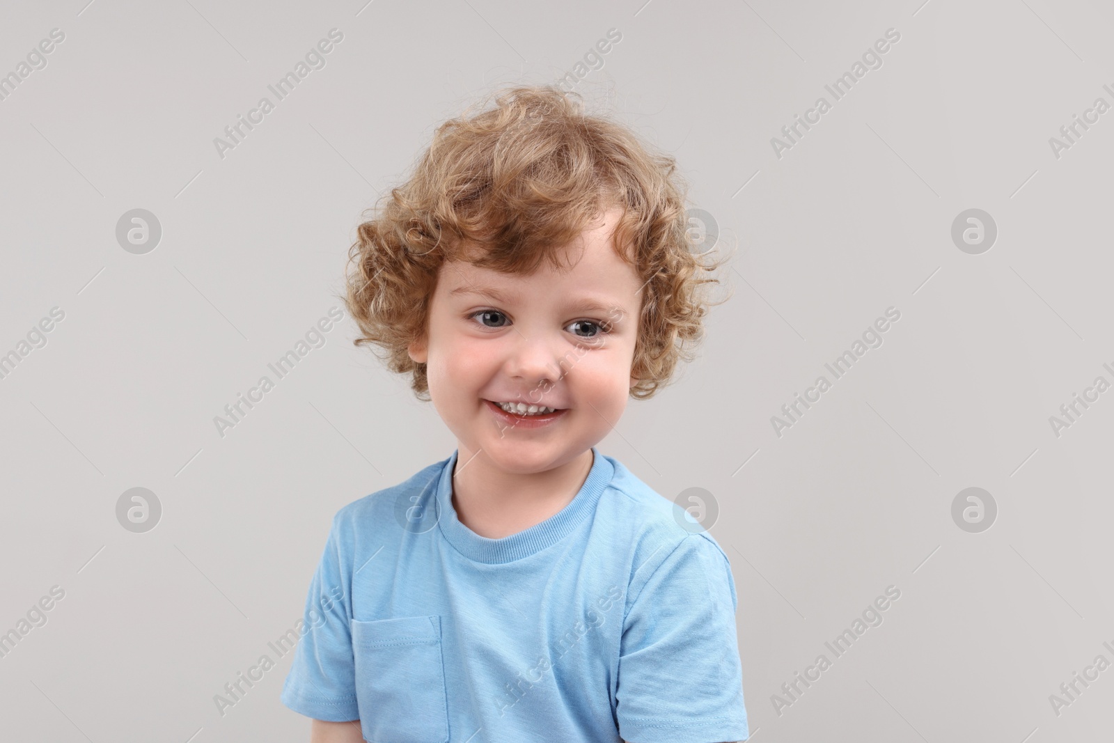 Photo of Portrait of cute little boy on grey background