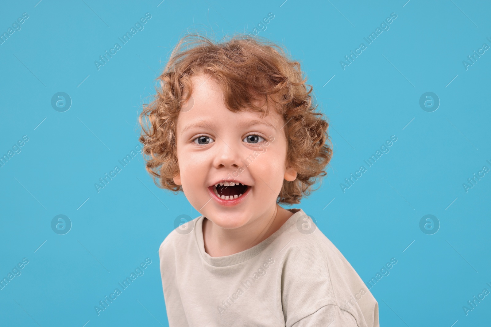 Photo of Portrait of cute little boy on light blue background