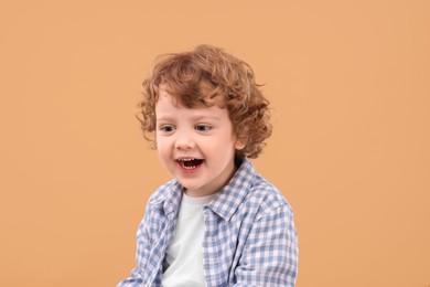 Photo of Portrait of cute little boy on beige background