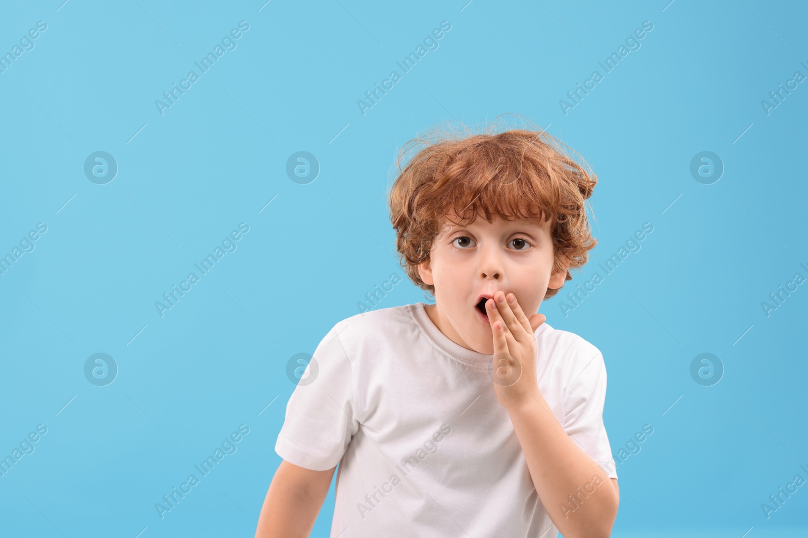 Photo of Portrait of emotional little boy on light blue background