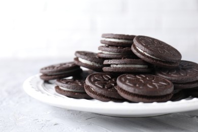 Many tasty sandwich cookies on light grey table