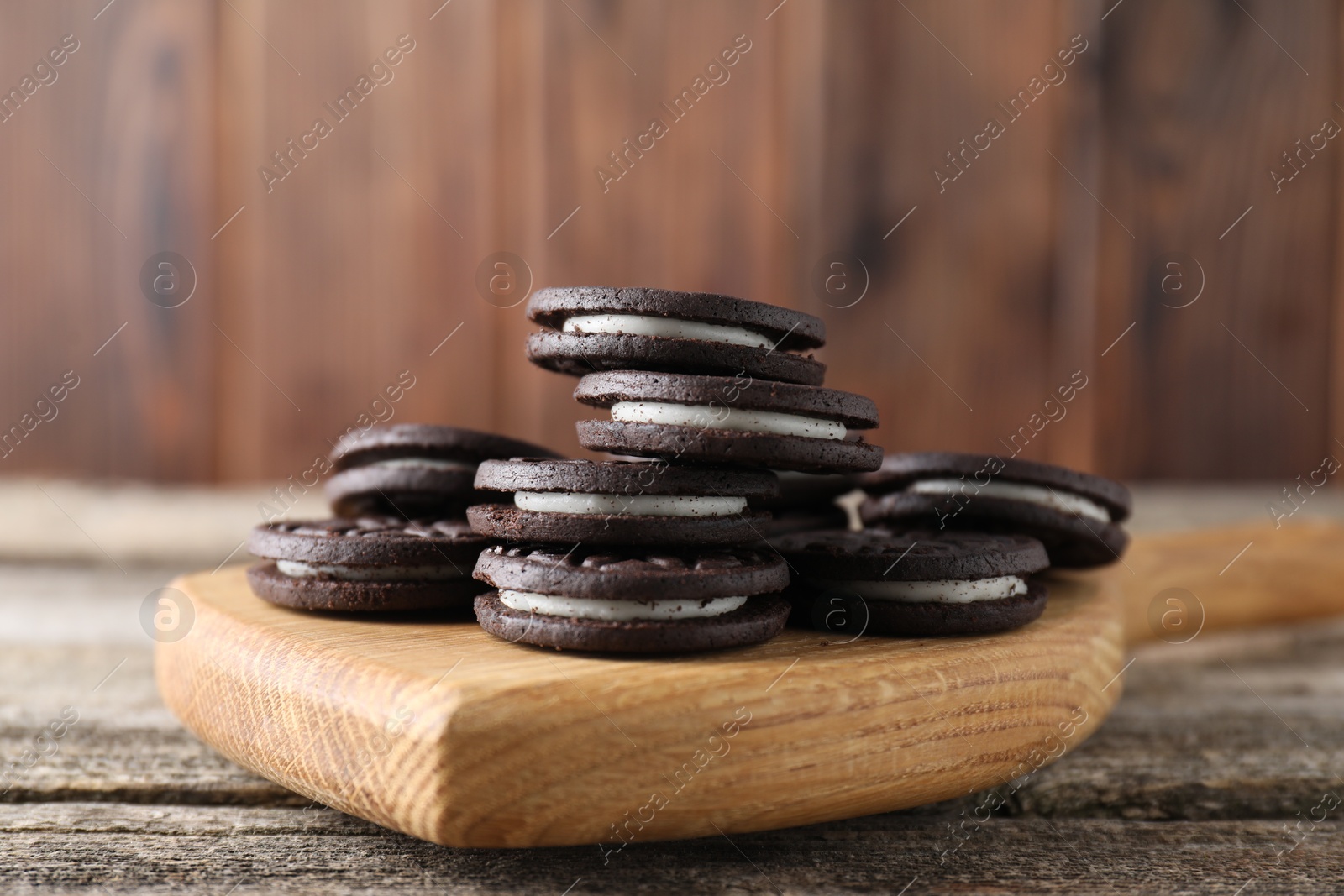 Photo of Many tasty sandwich cookies on wooden table