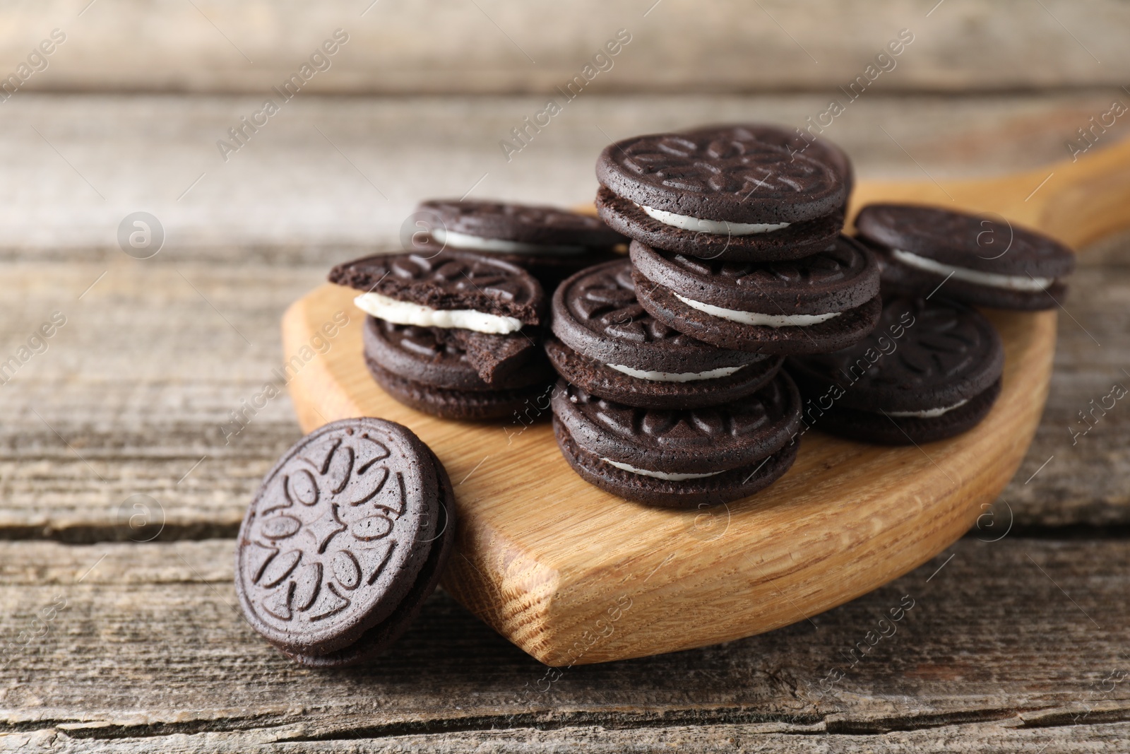 Photo of Many tasty sandwich cookies on wooden table