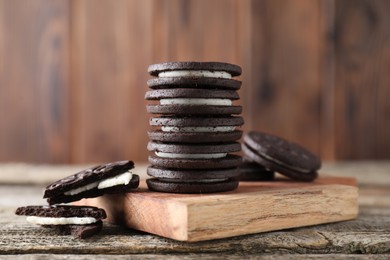 Many tasty sandwich cookies on wooden table