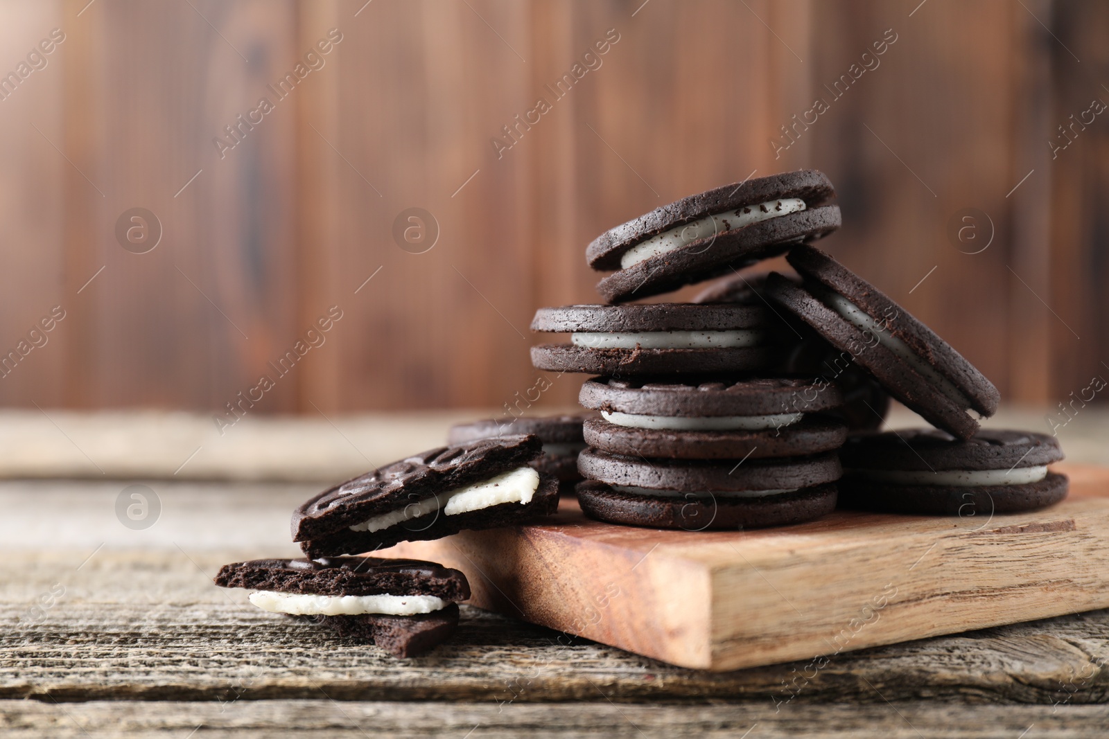 Photo of Many tasty sandwich cookies on wooden table. Space for text