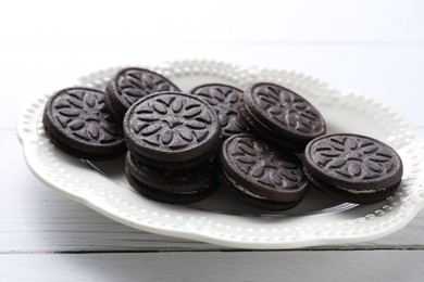 Photo of Many tasty sandwich cookies on white wooden table