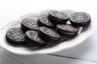 Photo of Many tasty sandwich cookies on white wooden table