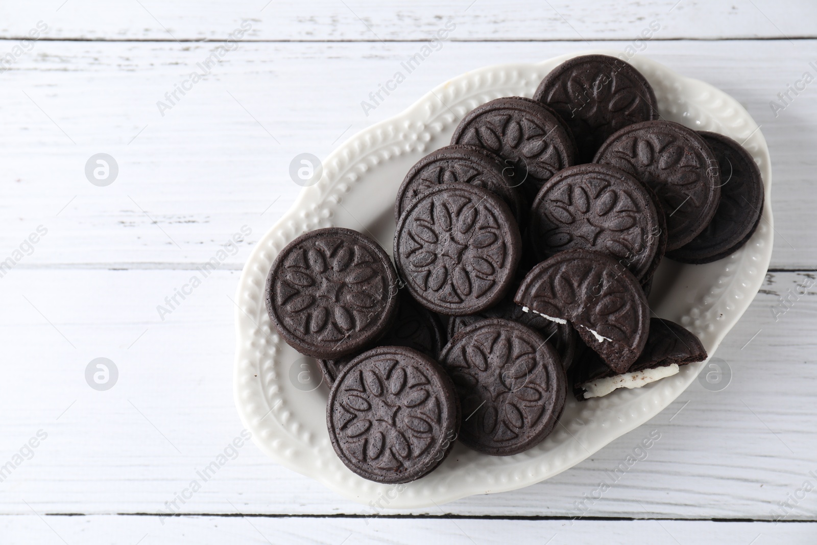 Photo of Many tasty sandwich cookies on white wooden table, top view. Space for text