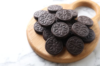 Photo of Tasty sandwich cookies on white marble table