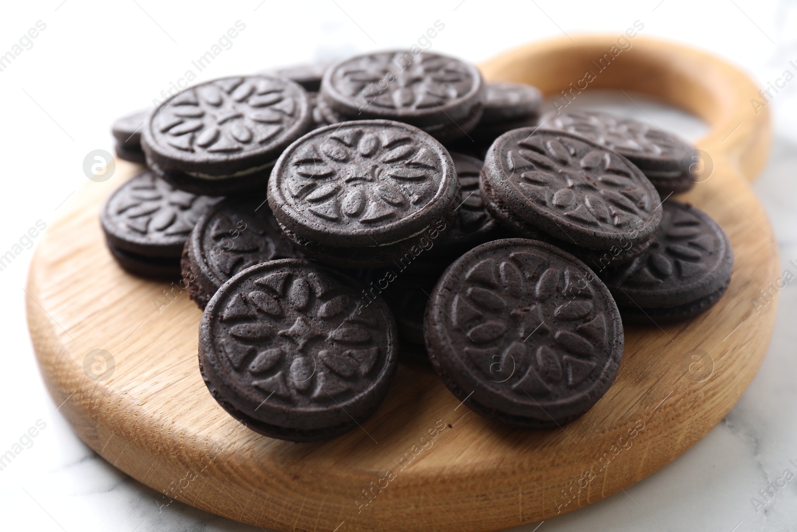 Photo of Tasty sandwich cookies on white marble table