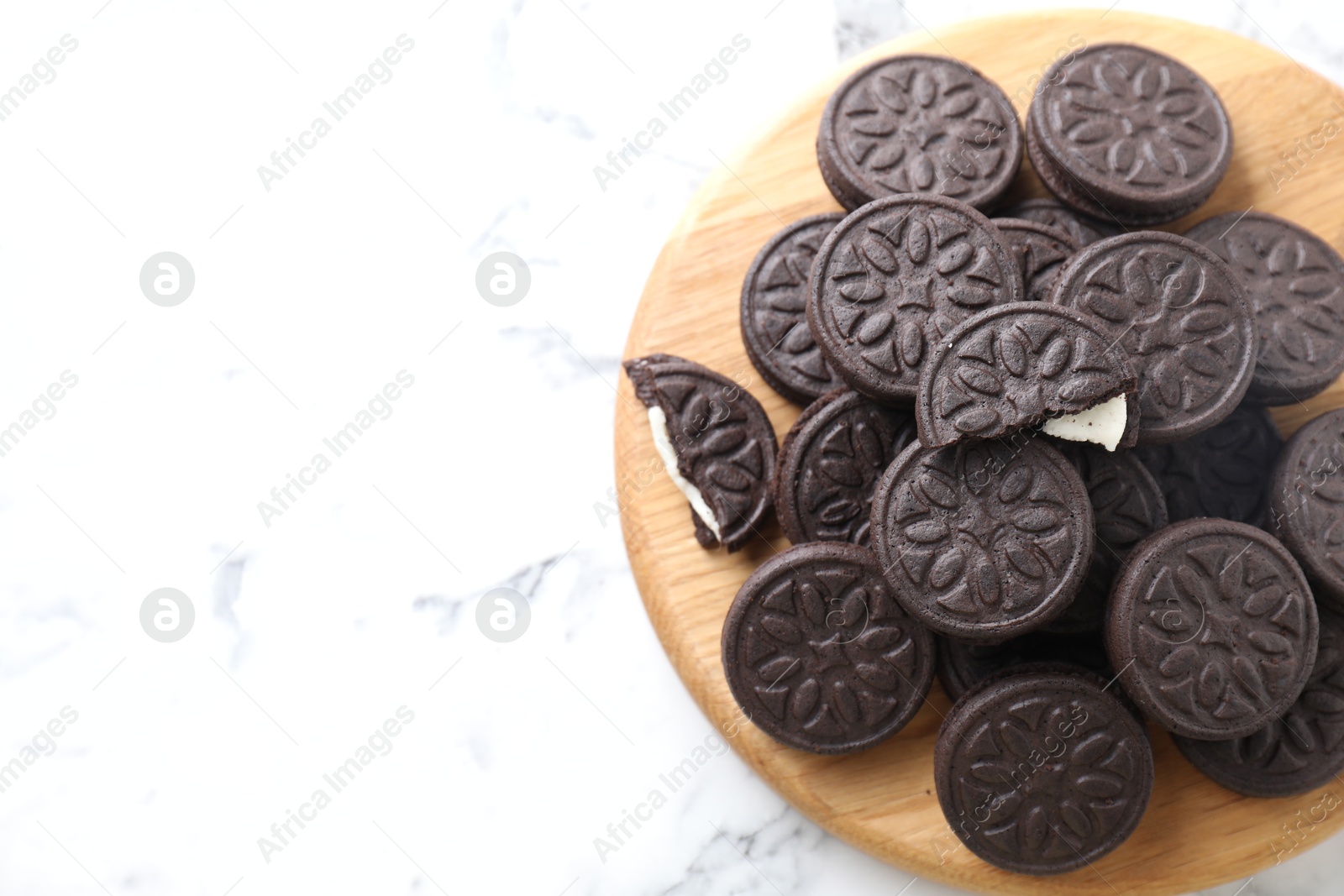 Photo of Tasty sandwich cookies on white marble table, top view. Space for text