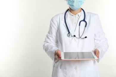 Doctor with tablet on white background, closeup view. Space for text