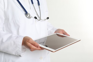 Doctor with tablet on white background, closeup view